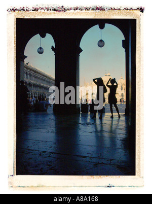 Zwei Figuren, die Silhouette im Torbogen vor der Basilika San Marco Venice Italy Stockfoto