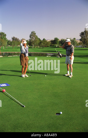 Paar in ihren 70ern, nur fehlt putt beim Golfen in Palm Springs, Kalifornien Stockfoto