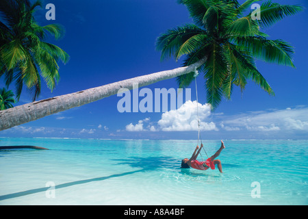 Frau, die Verlegung in Gange über Aqua Wasser unter Palme und cloud Stockfoto