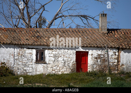 Typische alte Algarian Farmbuilding mit weiß gewaschen Wände und helle rote Tür. Algarve-Portugal-Europa-EU Stockfoto