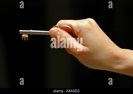 Hand, die einen Schlüssel Stockfoto