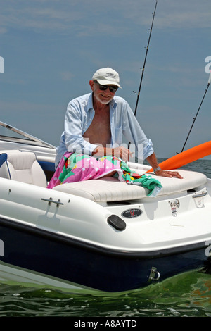 froh, dass moderne senior woman mit Angelrute auf das neue Schnellboot im Ruhestand Stockfoto