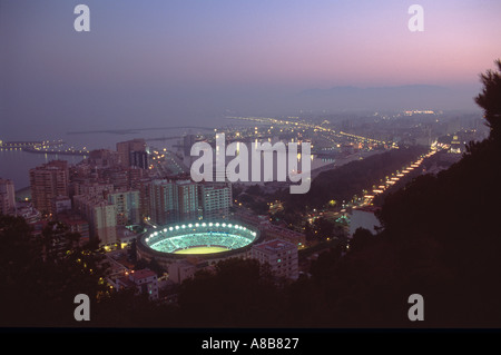 Mit Blick auf die Stadt in der Abenddämmerung von der Castillo de Gibralfaro zeigt den Hafen und die beleuchtete Stierkampfarena, Malaga, Andalusien, Spanien Stockfoto