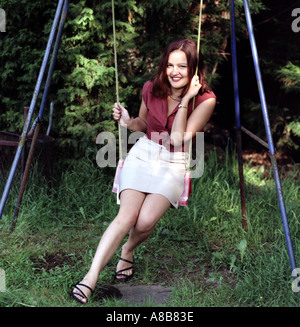 Porträt einer jungen Frau aus der Ukraine auf eine Gartenschaukel gefleckten Sonne sitzen Stockfoto