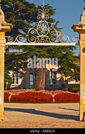 Das Eingangstor zum Chateau Beychevelle in Saint Julien. Wunderschöne Blumenarrangements und riesige Zeder Stockfoto