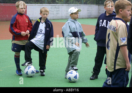 Jungs spielen Fußball im Schulhof Stockfoto