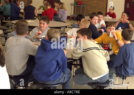 Jungen Alter 13 Essen und sprechen in Schule Kantine. Golden Valley, Minnesota USA Stockfoto