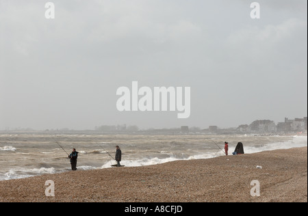 Meer-Angler mit stürmischer See Sandgate Strand Kent Stockfoto