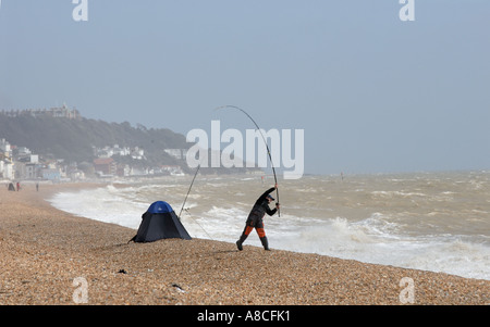 Meer-Angler mit stürmischer See Sandgate Strand Kent Stockfoto