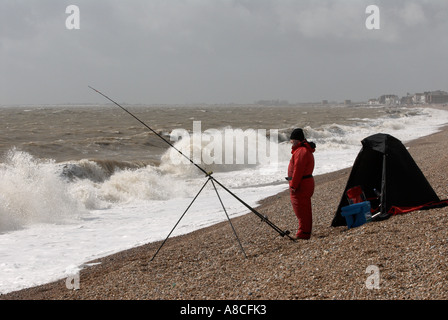 Meer-Angler mit stürmischer See Sandgate Strand Kent Stockfoto