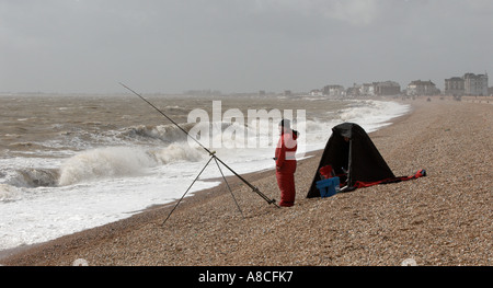 Meer-Angler mit stürmischer See Sandgate Strand Kent Stockfoto