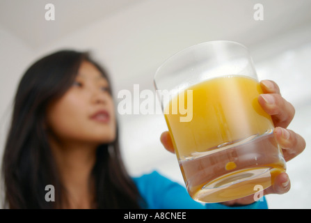 orientalische Frau mit einem gesunden Glas frisch gepresster Orangensaft Stockfoto