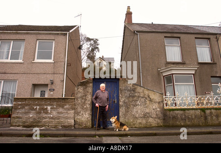 EIN ÄLTERER MANN VOR SEINEM HAUS IN SÜD-WALES MIT SEINEM CORGI HUND UK MÄRZ 2OO5 Stockfoto