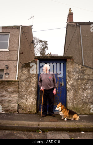 EIN ÄLTERER MANN VOR SEINEM HAUS IN SÜD-WALES MIT SEINEM CORGI HUND UK MÄRZ 2OO5 Stockfoto