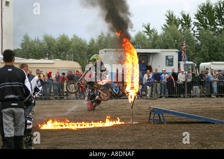 Stunt-Kind auf einem Motorrad durch Feuer springen Stockfoto