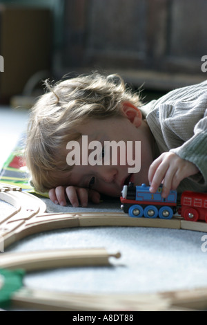 Lewis im Alter von drei spielen mit seiner wertvollen Holz Triebzug Stockfoto