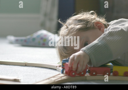 Lewis im Alter von drei spielen mit seiner wertvollen Holz Triebzug Stockfoto