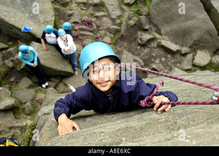Ein behindertes Kind klettern während auf einer Klassenfahrt im Peak District Stockfoto