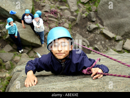 Ein behindertes Kind klettern während auf einer Klassenfahrt im Peak District Stockfoto