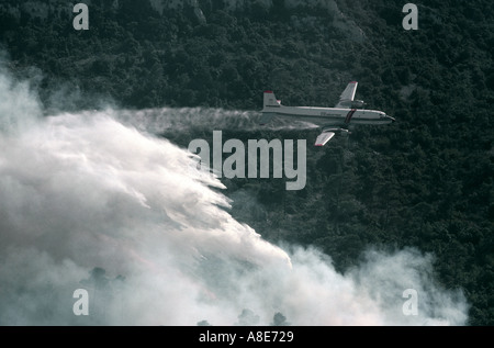 Luftaufnahme von eine Douglas DC-6B Löschwasser bomber Flugzeug fallen Wasser über ein wildfire, Feuer Wald Rauch, Provence, Frankreich, Europa, Stockfoto