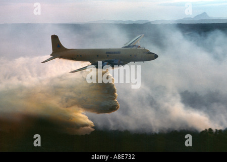 Luftaufnahme von eine Douglas DC-6B Löschwasser bomber Flugzeug fallen Feuerhemmende über ein wildfire, Feuer Rauch, Provence, Frankreich, Europa, Stockfoto