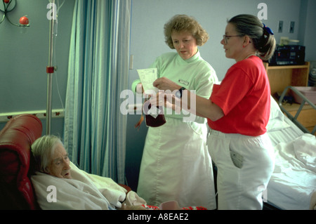 Krankenschwestern, Blutspenden, Patientenalter 90 & 40 im Krankenhaus Hospiz. Robbinsdale Minnesota USA Stockfoto