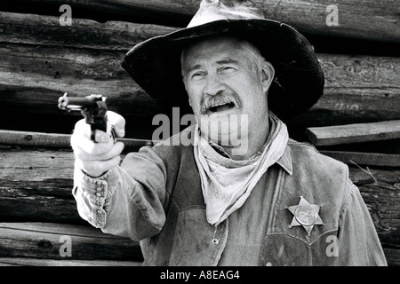 Ein Sheriff Cowboy Reenactor mit seiner Pistole zeigte und sprechen Stockfoto