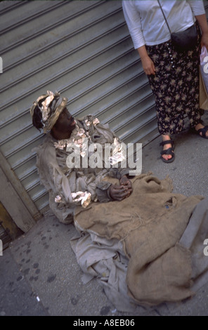 Obdachlose Bettler Alter von 38 Jahren in Lumpen auf Bürgersteig sitzen. New York-New York-USA Stockfoto