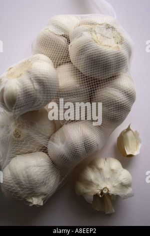 Tasche von Knoblauch mit einem geöffneten Wendekreis mit einer Knoblauchzehe A stark riechenden scharf schmeckenden Glühbirne verwendet als Gewürz in der Küche und im Kräutergarten Stockfoto