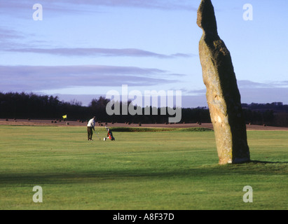 dh Neolithische stehende Stein LUNDIN LINKS GOLF FIFE SCHOTTLAND Scottish Golfer spielen auf Golfplätzen Mann Menschen UK Stockfoto