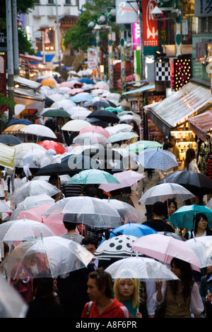 Regen fällt auf Regenschirme in belebten Takeshita-Straße in Harajuku Tokio Japan Stockfoto