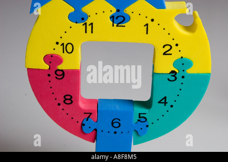Spielzeug, Puzzle, Uhr, zahlen, Kunststoff, Fälschung, Farben, rot, gelb, grün, blau, Nahaufnahme, grauen Hintergrund Stockfoto