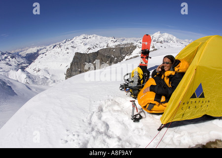 Weibliche Bergsteiger macht Zelle / SA Anruf von Camp in alpiner Umgebung. Stockfoto