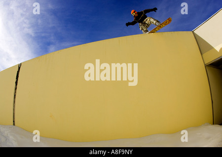 Städtischen Snowboarder gleiten eine Wand im Skidorf Stockfoto