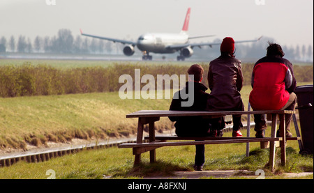 Drei Flugzeugbeobachter saß auf einem picknicktisch beobachten ein Flugzeug vom Flughafen Schiphol Amsterdam nehmen Stockfoto