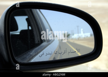 Dubai-Spiegel des Autos mit arabischen Buchstaben Objekte im Spiegel sind näher als sie erscheinen. Foto: Willy Matheisl Stockfoto