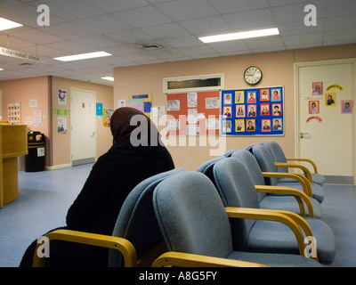 Muslimische Frau sitzt in einem Wartezimmer in Matiernity Einheit in einem NHS Krankenhaus, England Stockfoto