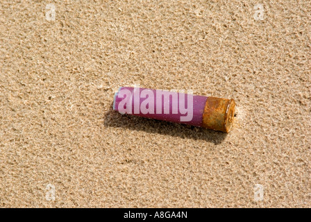 Verbrauchte 12 gauge Shotgun Shell auf Strandsand Stockfoto