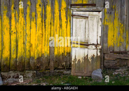 Baufälligen Schuppen mit gelber Farbe und Tür, Morzine-Avoriaz, Frankreich. Stockfoto