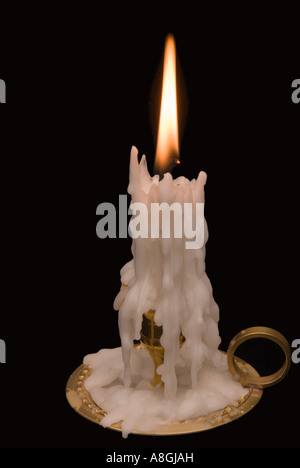 Kerze auf schwarzem Hintergrund in Messing Kerzenständer. Stockfoto