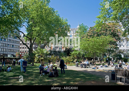 Hanover Square Garden, Central London, werktags Mittagszeit mit blühenden Bäumen, Arbeiter genießen Sonnenschein, Menschen gehen, London, England, UK Stockfoto