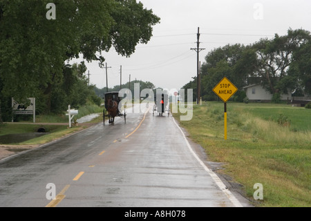 Amische Wagen auf Regen Slicked Straße Yoder Kansas Stockfoto