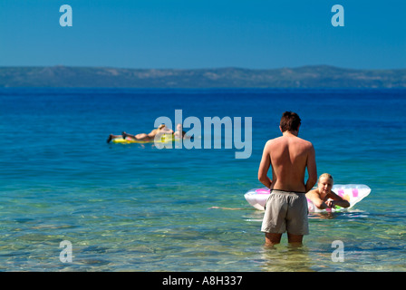 Urlauber, die schwimmend auf Strandbäder in der Adria vor der Küste von Makarska, Dalmatien, Kroatien Stockfoto