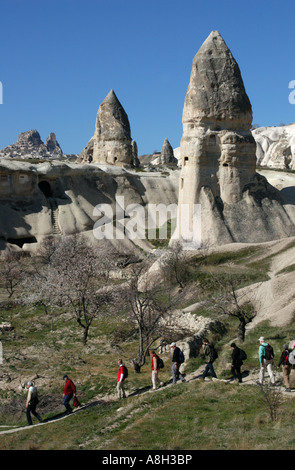 Touristen vor den Steinkaminen mit künstlichen Höhlen im Taubental bei Goreme in Kappadokien, Türkei Stockfoto