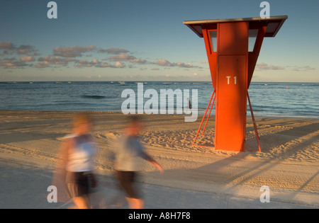 Ein paar Mann und Frau genießen einen Morgenspaziergang entlang einem ruhigen Teil von Waikik Strand Oahu USA Stockfoto