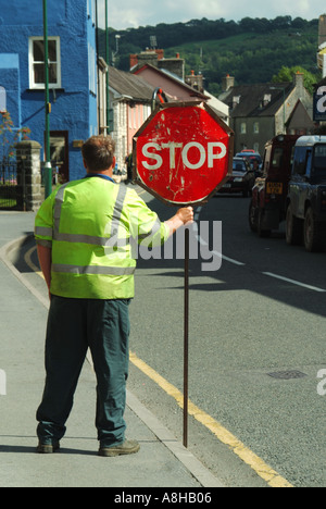 Workman Stop in Betrieb gehen Board zur Steuerung Verkehr durch Straßenarbeiten Stockfoto