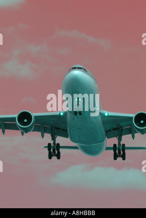 Jet-Passagierflugzeug ins Land kommen eine einen Flughafen mit einer manipulierten rot orange Sky Stockfoto