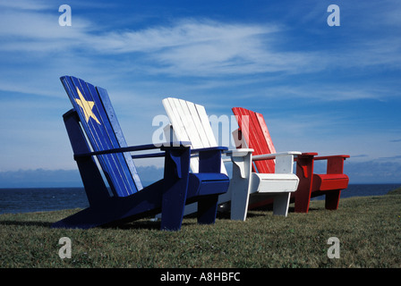 Adirondack Stühle gemalt wie die Acadian Flagge an der Küste der Bucht von Chaleur New Brunswick, Kanada Stockfoto
