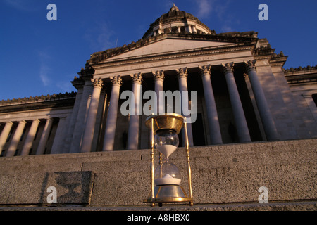 Sandkörner fallen auf Grund von Messing antik Sanduhr auf Stufen des Washington State Capitol Building bei Sonnenuntergang in Olympia WA Stockfoto