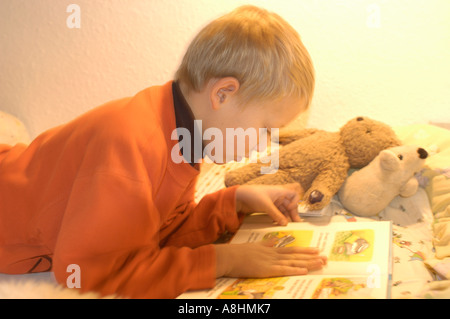 Sieben Jahre alter Junge liest ein Buch Stockfoto